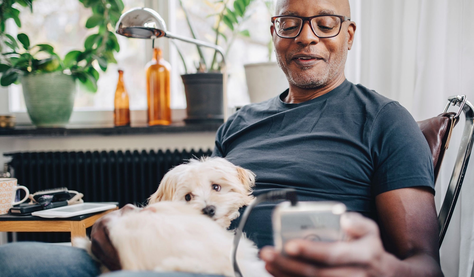 Happy man and dog, man using mitouch pain management device and for pain relief and recovery